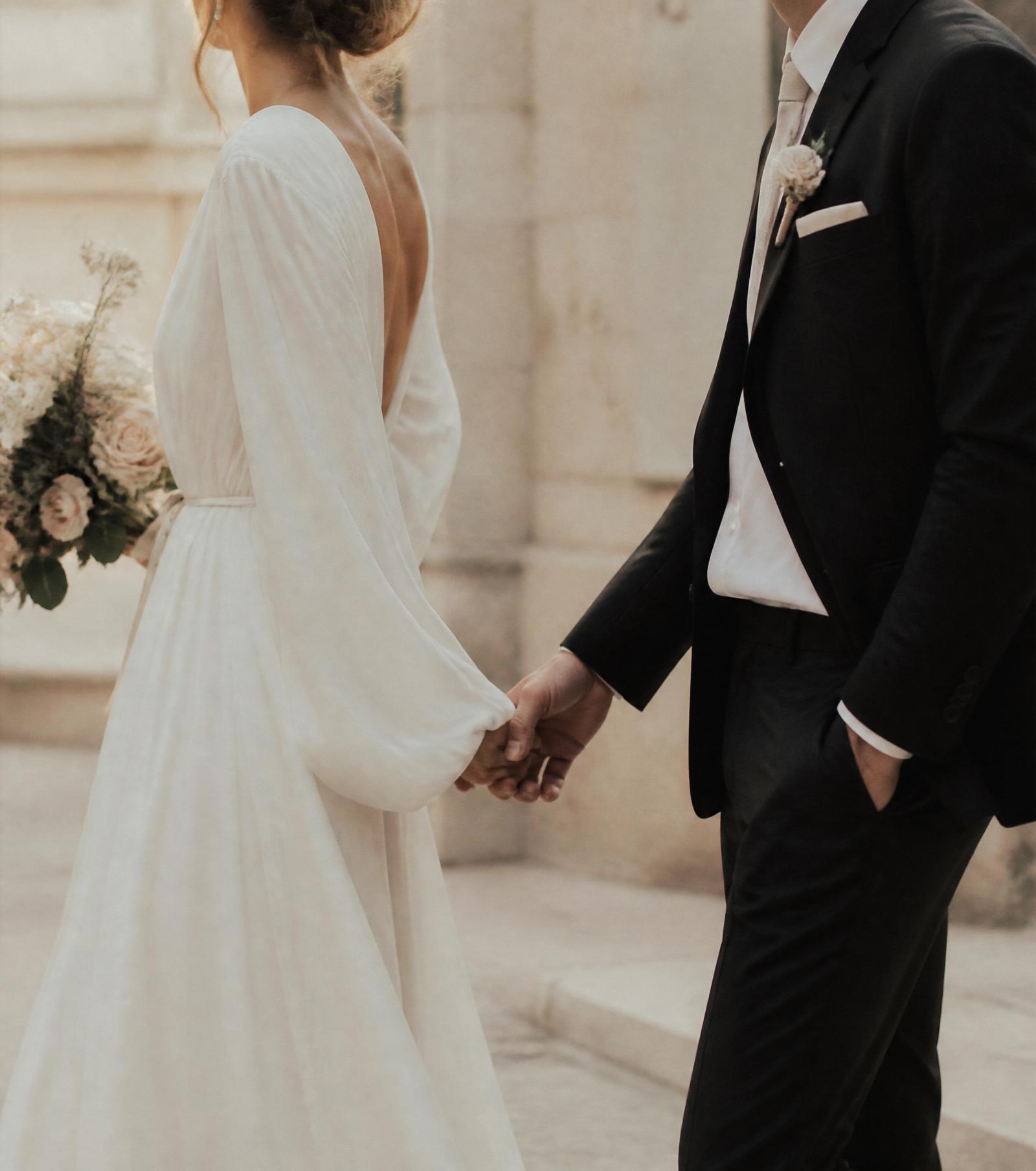A couple on their wedding day, quietly holding hands